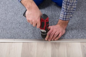 Carpet Fitter Installing Carpet With Wireless Screwdriver Top Quality Flooring Store